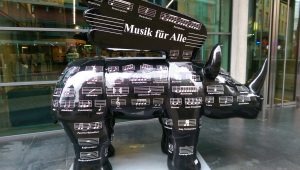 A sculpture of a winged rhinoceros. It is decorated with puns based on musical words and phrases.